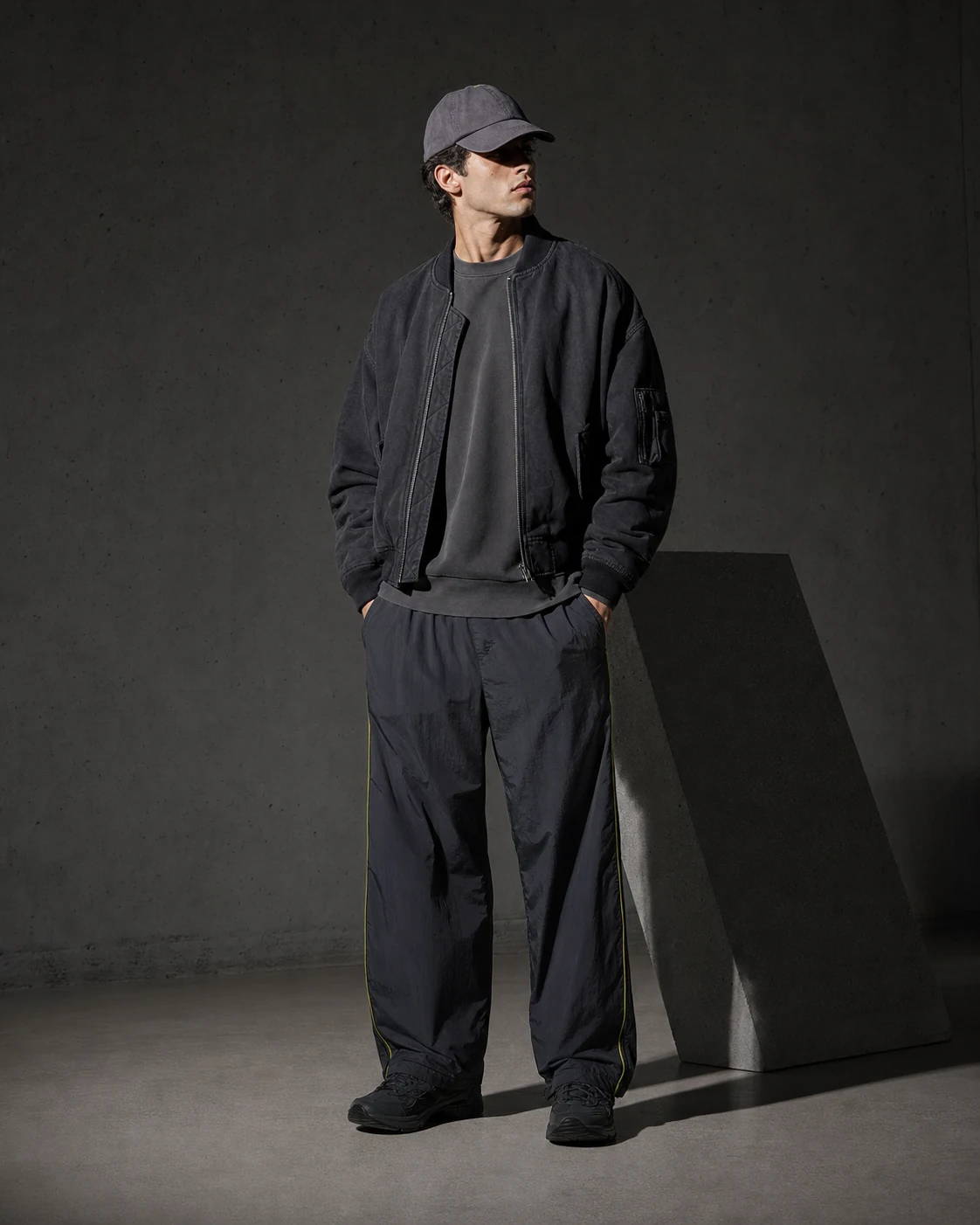 Model wearing a layered streetwear look, studio