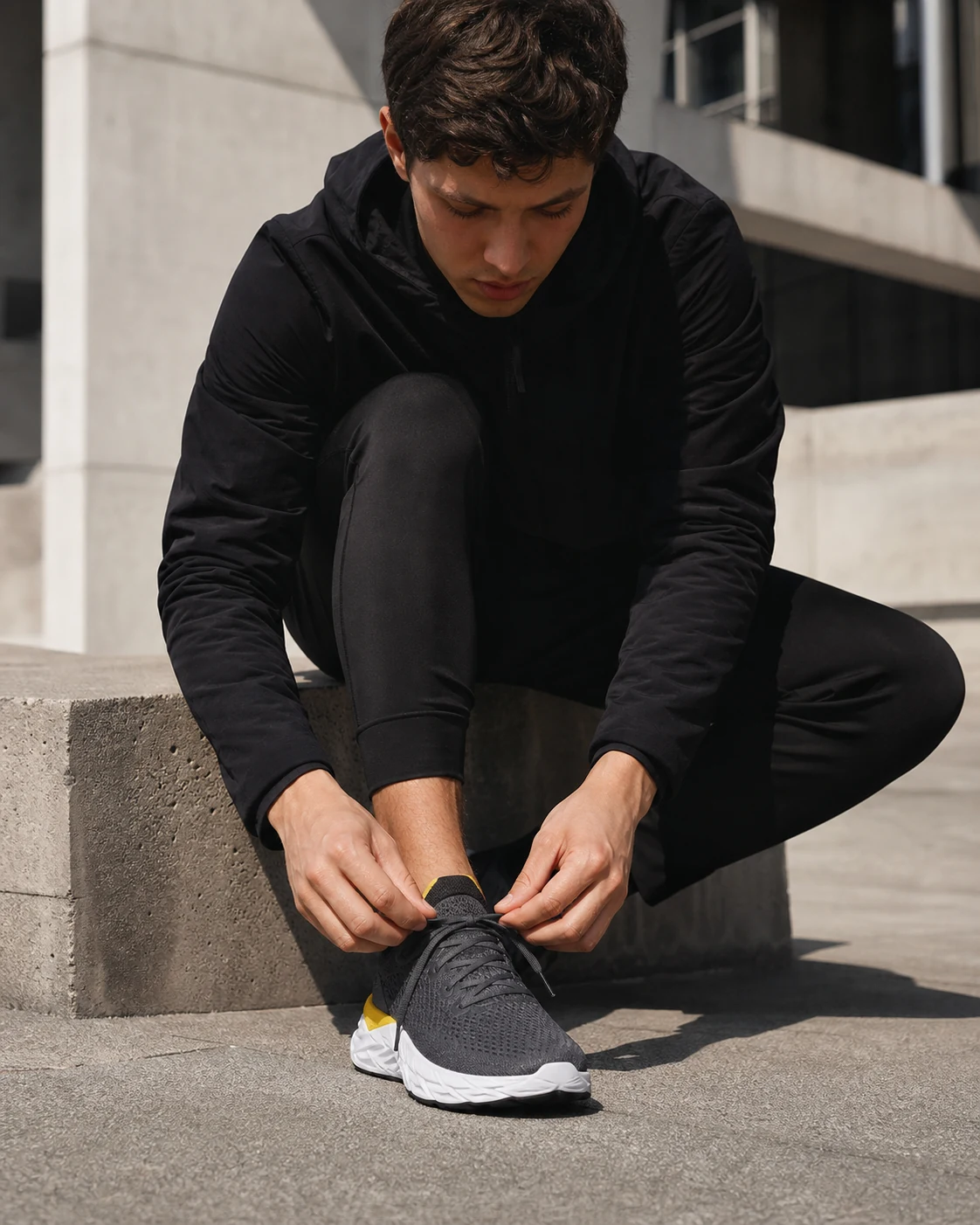 Person lacing up sneakers, urban setting